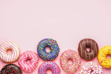 Tasty glazed donuts on pink background, closeup