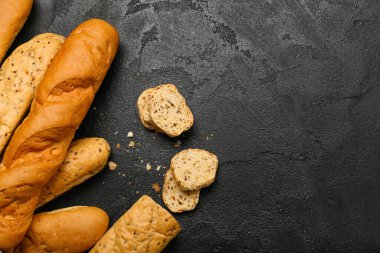 Loaves of fresh baguette on black background