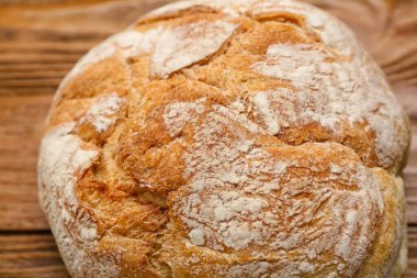 Loaf of fresh bread on wooden background, closeup