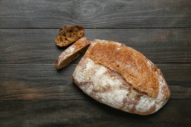 Sliced loaf of fresh rye bread on black table