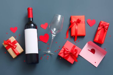 Composition with bottle of wine, glass and gifts on dark background. Valentines Day celebration