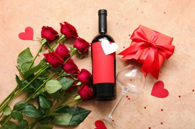 Bottle of wine, rose flowers and hearts on beige background. Valentine's Day celebration