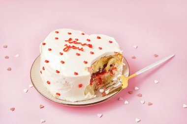 Plate with heart-shaped bento cake on pink background. Valentine's Day celebration