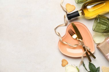 Table setting with bottle of wine, glasses, cookies and rose flower on white background. Valentine's Day celebration