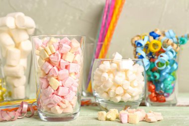 Glasses of tasty marshmallows and serpentine on table