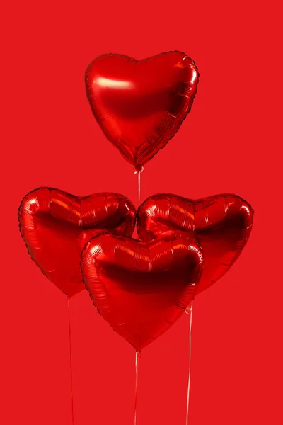 Heart shaped balloons for Valentine\'s Day on red background