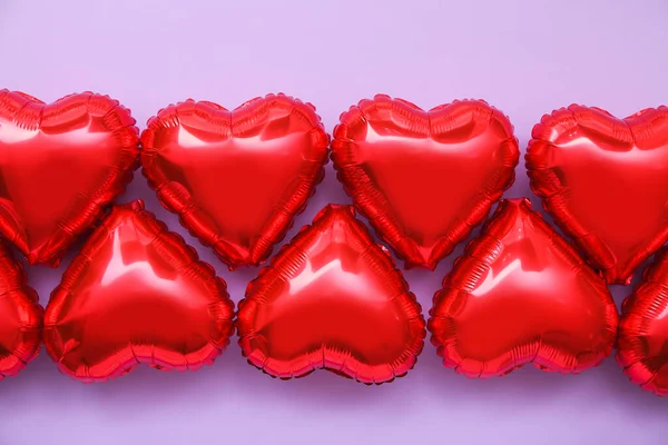 Red heart shaped balloons on color background, closeup. Valentine\'s Day celebration
