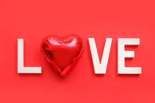 Word LOVE made of white letters and balloon on red background. Valentine\'s Day celebration