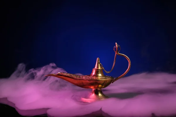 Aladdin lamp of wishes with smoke for Ramadan on table against dark blue background