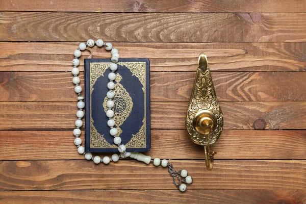 Aladdin lamp of wishes, Koran and prayer beads for Ramadan on wooden background