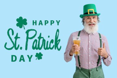 Mavi arka planda bir bardak birası olan mutlu son sınıf öğrencisi. Aziz Patrick Günü kutlaması