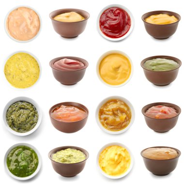 Collection of tasty sauces in bowls on white background