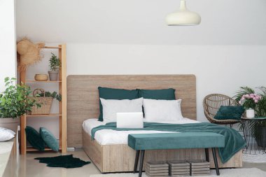 Big bed and bench in interior of light room