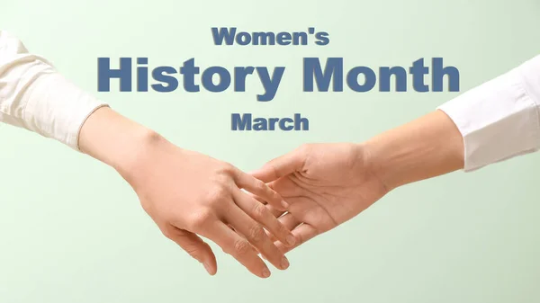 Hands of women on light green background. Women\'s History Month