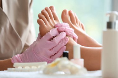 Young woman getting pedicure in beauty salon, closeup