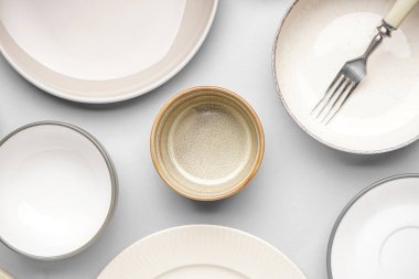 Different clean dishware on grey background