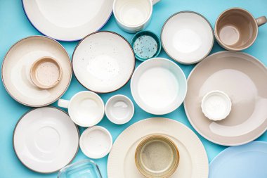 Different clean dishware on blue background