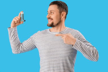 Man with inhaler on blue background
