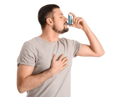 Sick man with inhaler on white background