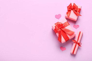 Gift boxes and paper decor on pink background. Valentine's Day celebration