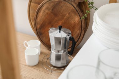 Geyser coffee maker and cups on counter in kitchen