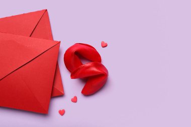 Envelopes and tasty fortune cookies on lilac background. Valentine's Day celebration