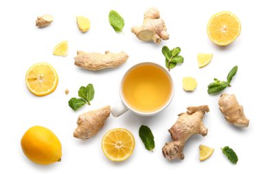 Composition with cup of tea, ginger and mint on white background