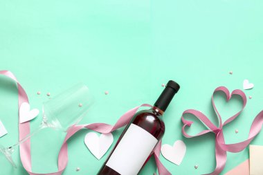 Composition with bottle of wine, glass and ribbon on color background. Valentines Day celebration
