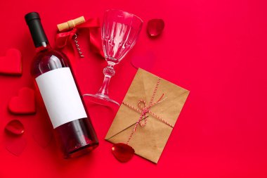 Composition with bottle of wine, glass and envelope on red background. Valentines Day celebration