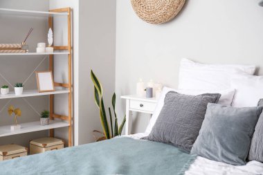 Interior of bedroom with burning candles on end table