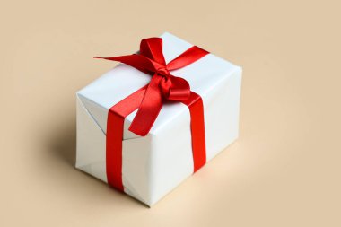 Gift box with beautiful bow on beige background. Valentine's Day celebration