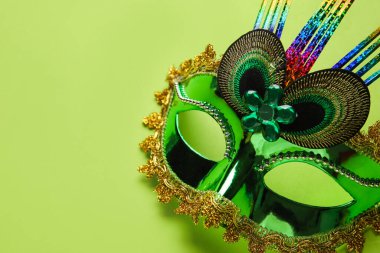 Carnival mask for Mardi Gras celebration on green background, closeup