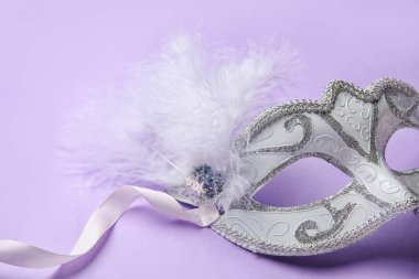 Carnival mask for Mardi Gras celebration on lilac background