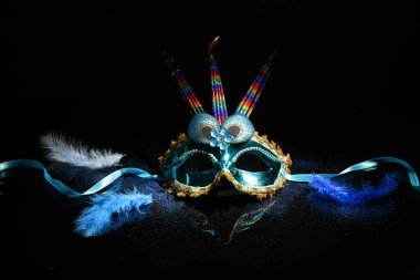 Carnival mask with glitter for Mardi Gras celebration on dark background