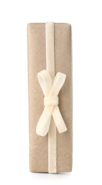 Gift box wrapped in craft paper with velvet ribbon on white background