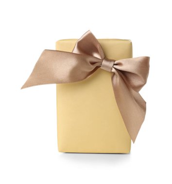 Gift box wrapped in yellow paper with silk bow on white background