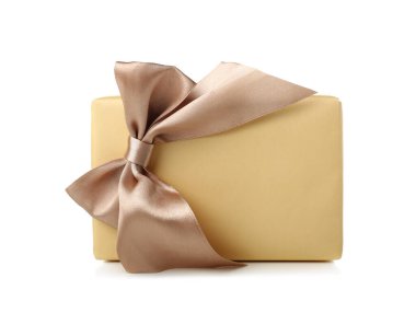 Gift box wrapped in yellow paper with silk bow on white background