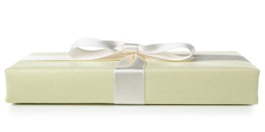 Gift box wrapped in yellow paper with silk ribbon on white background