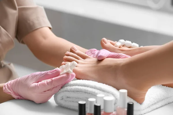 stock image Beautician putting toe separator on woman's leg in salon, closeup