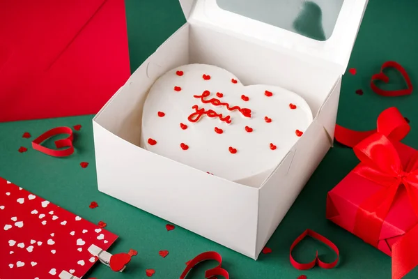 Opened box with tasty bento cake on green background. Valentine\'s Day celebration