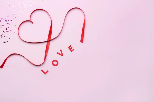 Word LOVE and heart made of red satin ribbon on pink background. Valentine\'s Day celebration