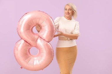 Beautiful mature woman with balloon in shape of figure 8 on lilac background. International Women's Day