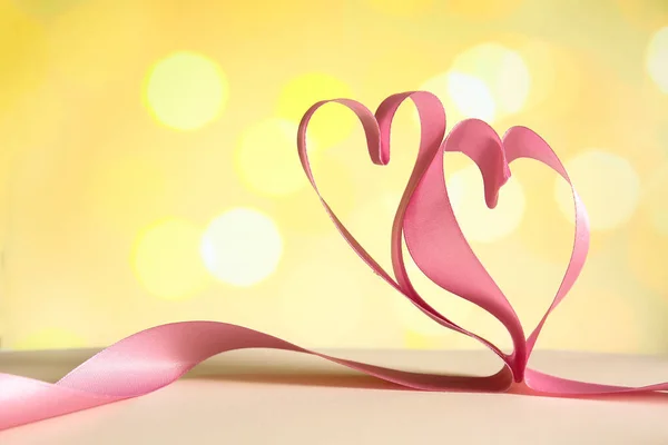 Серця Рожевої Атласної Стрічки Столі Проти Розмитих Вогнів — стокове фото