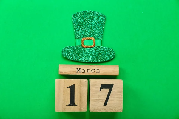 Calendar with date of St. Patrick\'s Day and decor on green background
