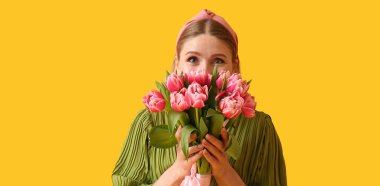 Sarı arka planda bir buket lale olan güzel bir kadın. Uluslararası Kadınlar Günü