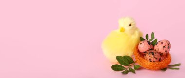 Cute yellow chicken and Easter eggs in nest on pink background with space for text