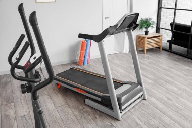 Interior of gym with modern treadmill and sport equipment