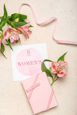 Composition with gift box, greeting card and alstroemeria flowers for Women's Day celebration on light background