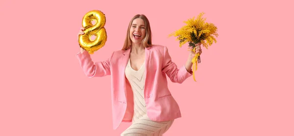 Happy woman with balloon in shape of figure 8 and mimosa flowers on pink background. International Women\'s Day