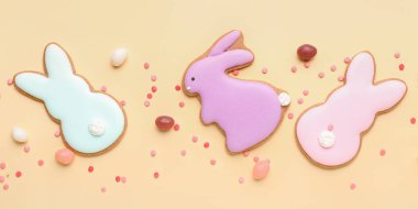 Beautiful Easter cookies with candies and sprinkles on light background